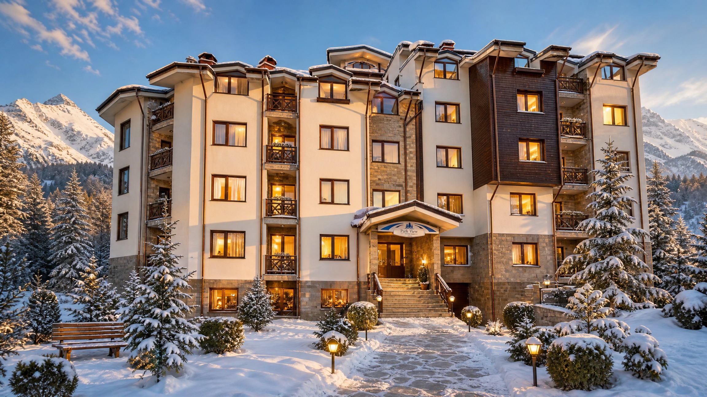 The ParkView building in Bansko on a winter evening, its windows lit, with the Pirin mountains behind